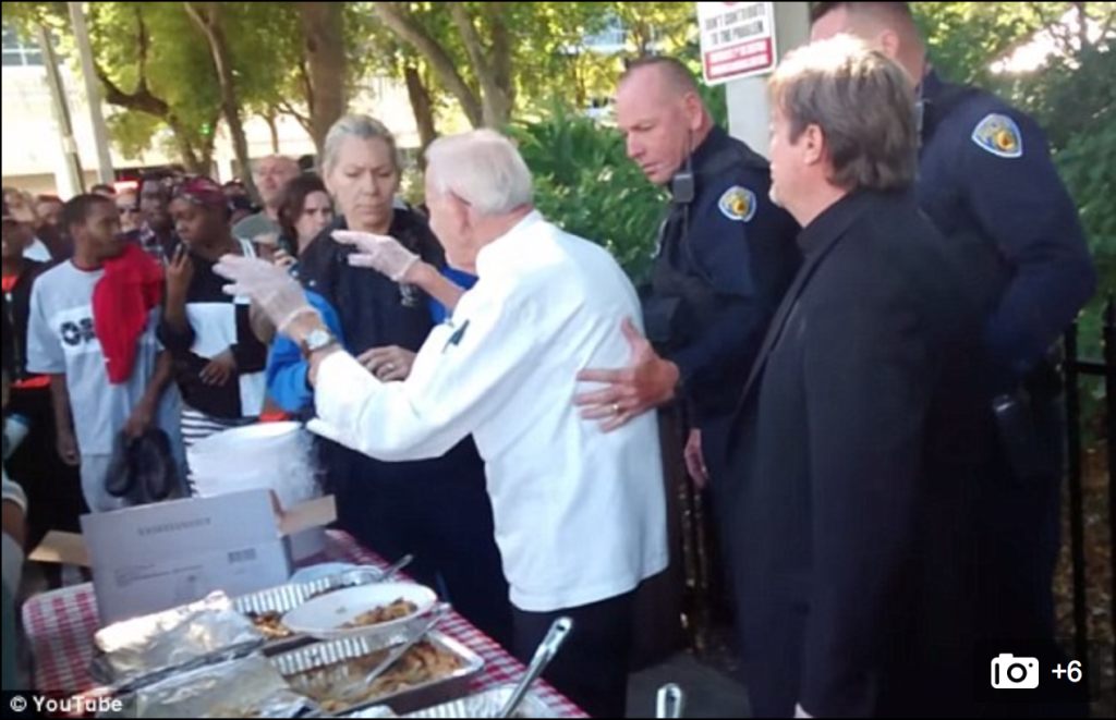 Hands off that plate! Officers demanded that Mr Abbott stop feeding the homeless people at once. / YouTube 