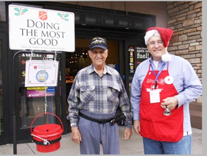 Jimmy Greco makes a donation as Joseph Callaway rings at bell for Salvation Army kettle in front of Fry’s grocery store at 64th Street and Greenway Road. / Photo: Courtesy of Those Callaways 