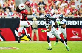 Wide receiver Larry Fitzgerald pulls in a pass in front of Seattle cornerback Richard Sherman during last year's game between the teams at University of Phoenix Stadium.