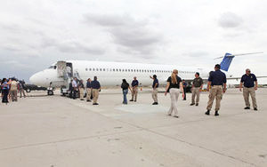 Immigration and Customs Enforcement officials board a plane in Tucson that is headed for Mexico City under the agency’s immigrant repatriation flights program in this 2011 :file photo.