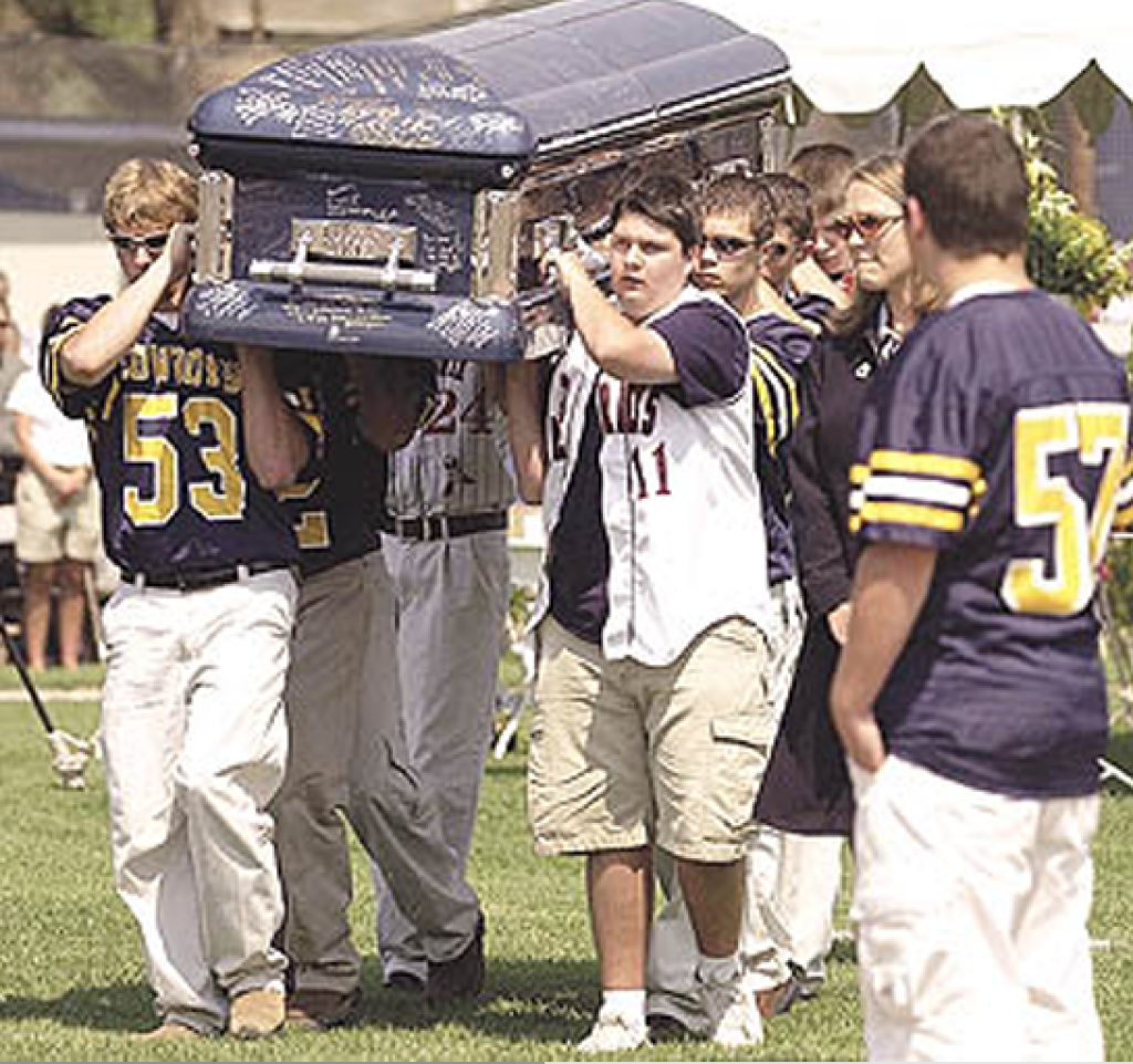 Pallbearers carry Brandon Patch's casket during his funeral at Denton Field in Miles City. Teammates and friends signed the casket and wrote messages to Brandon./James Woodcock/Billings Gazette 