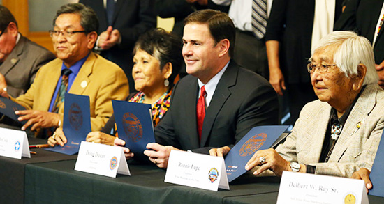 Gov. Doug Ducey, center, signs amendment to Arizona's tribal gaming compact, along with leaders from eight tribes. /Photo by Rachel Leingang, Arizona Capitol Times